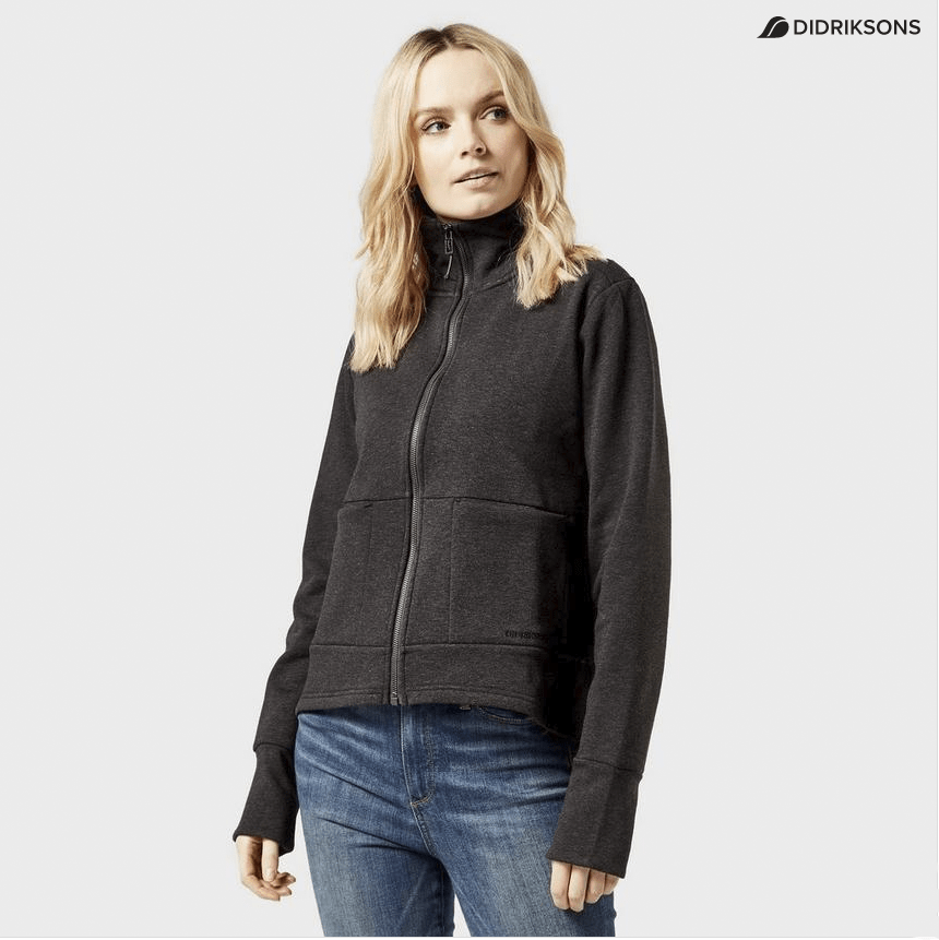 Woman modeling a dark grey zip-up jacket and blue jeans with a light background
