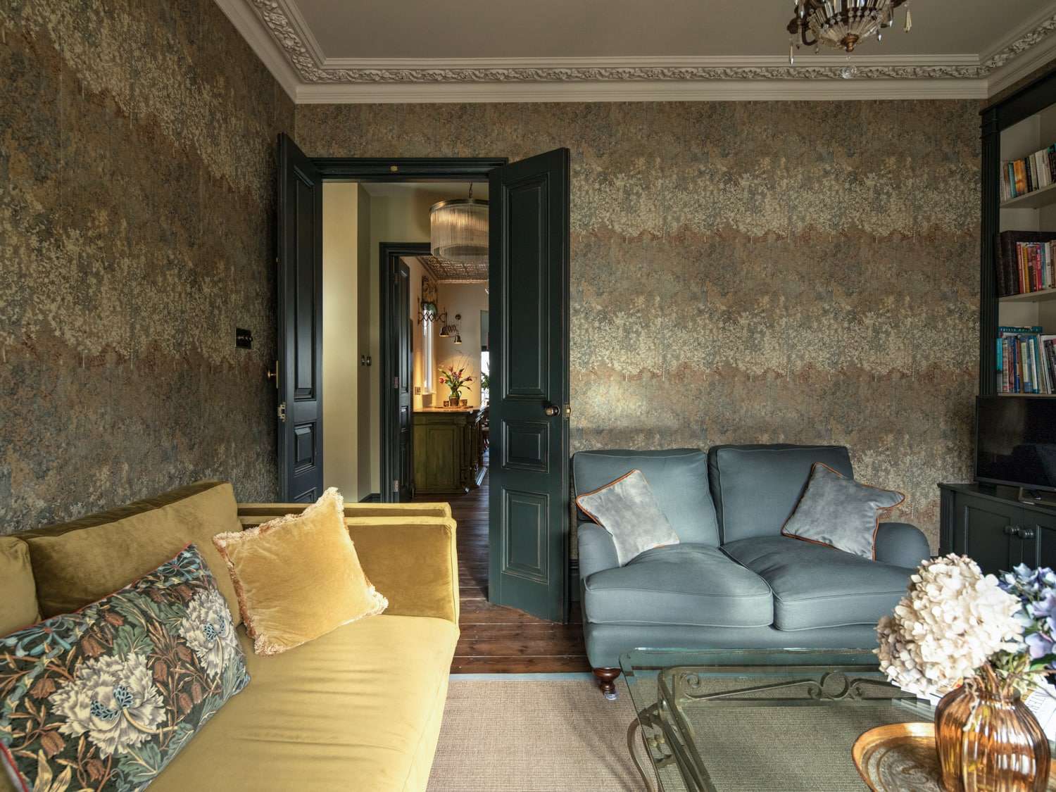 A luxurious vintage-styled living room with textured walls, plush sofas, and antique decorations.