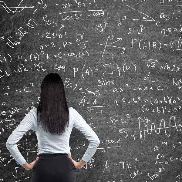 girl looking at board with lots of mathematical symbols.